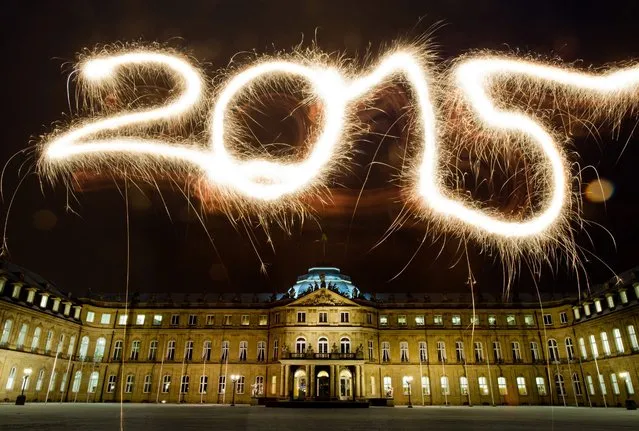 A long exposure picture shows the number 2015 written with sparklers in the air in front of the “Neues Schloss” (New Palace) in Stuttgart, Germany, 29 December 2014, during preparations for New Year's Eve celebrations. (Photo by Inga Kjer/EPA)