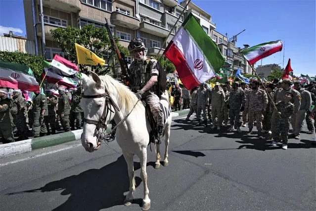 A member of the Iranian paramilitary Basij force rides a horse while attending a rally to mark Jerusalem Day, an annual show of support for the Palestinians, in Tehran, Iran, Friday, April 14, 2023. (Photo by Vahid Salemi/AP Photo)