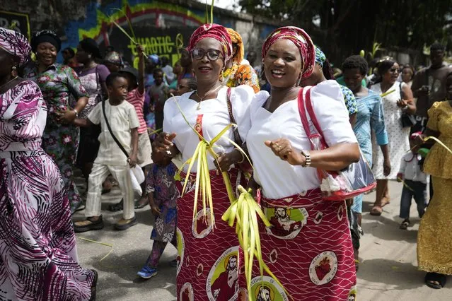 Catholic faithfuls march carrying Palm fronds to commemorate Palm Sunday, which marks the entry of Jesus Christ into Jerusalem, on the streets of Lagos, Nigeria, Sunday, April 2, 2023. The ceremony marks the beginning of the Holy Week leading to Easter. (Photo by Sunday Alamba/AP Photo)