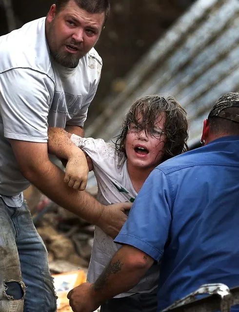 A child calls to his father after being pulled from the rubble of the Tower Plaza Elementary School. (Photo by Sue Ogrocki/Associated Press)