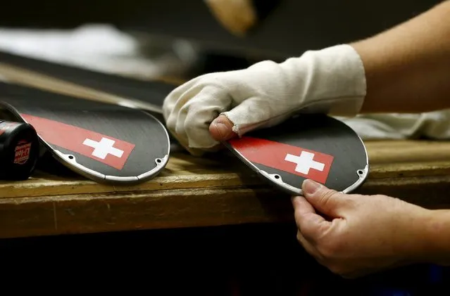 An employee places an edge protector on a ski at the plant of Swiss ski manufacturer Stoeckli in Malters, Switzerland November 25, 2015. (Photo by Arnd Wiegmann/Reuters)