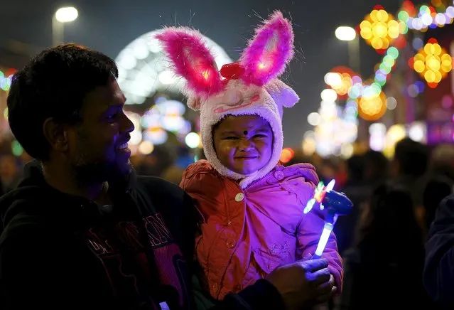 A girl reacts to the camera after the switching on of Diwali lights in Leicester, Britain, November 1, 2015. The Diwali celebration in Leicester is one of the largest in the world outside of India, with around 35,000 people attending the switch-on of the lights in the heart of the city's Asian community. (Photo by Darren Staples/Reuters)