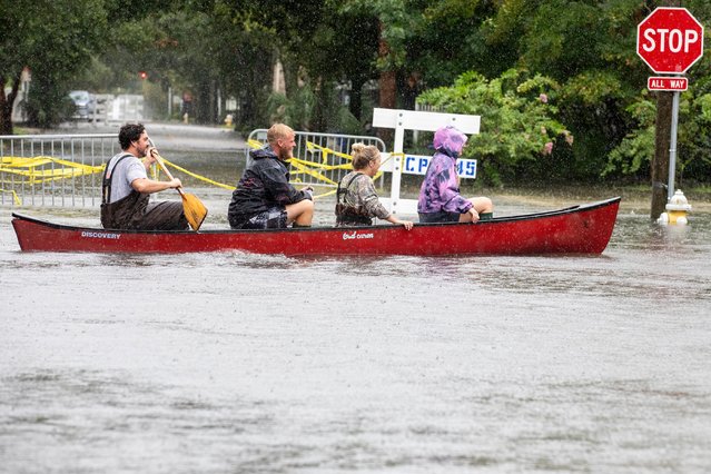 Trip Hamilton paddles his friends Brandin Gates, second from left, Mallie Taylor, second from right, and Ellie Combs, right, all from Charleston, S.C., in a canoe down Ashley Ave. in Charleston as Tropical Storm Debby approaches, Tuesday, August  6, 2024. (Photo by Mic Smith/AP Photo)