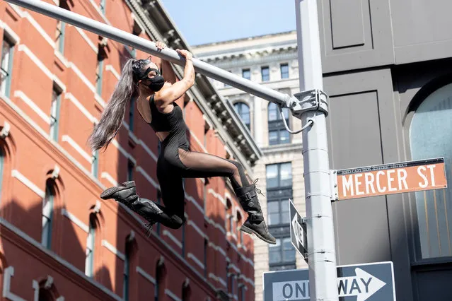 Natalie Duran, wearing a mask and dressed as Catwoman, climbs on street lights in SoHo as the city continues Phase 4 of re-opening following restrictions imposed to slow the spread of coronavirus on July 25, 2020 in New York City. The fourth phase allows outdoor arts and entertainment, sporting events without fans and media production. (Photo by Alexi Rosenfeld/Getty Images)