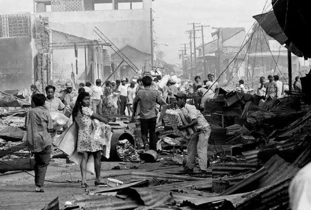 Looters carry their goods on December 27, 1972 in Managua, amid the rubble of earthquake destroyed Managua, Nicaragua, last Tuesday. (Photo by AP Photo)