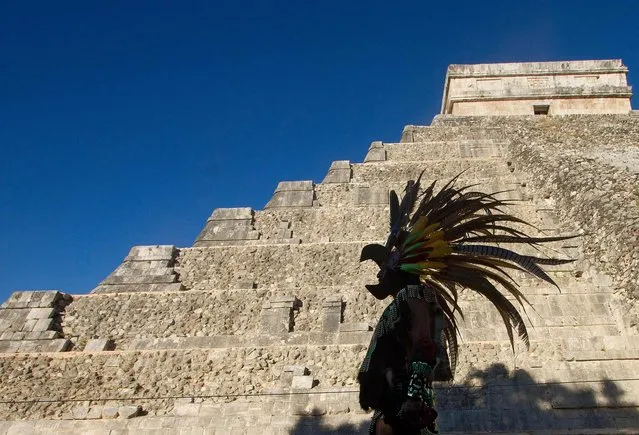 A Mexican man wearing a pre-hispanic costume walk next to the Kukulkan pyramid at the Chichen Itza archaeological park, in Yucatan state, Mexico on December 20, 2012. A pyramidal structure that could be from the 550 to 800 A.D. was found inside the Kukulkan temple, Mexican archaeologists and engineers said on November 16, 2016. (Photo by Pedro Pardo/AFP Photo)