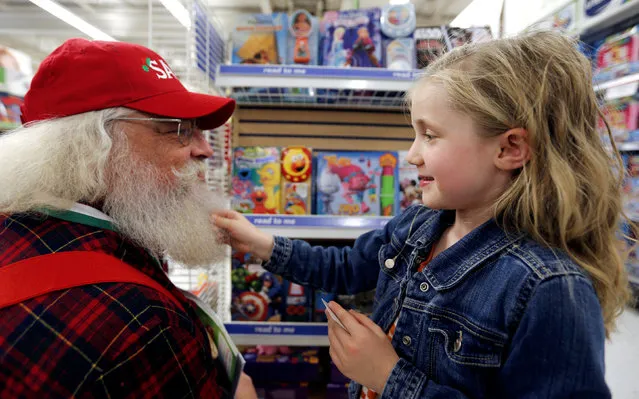 Five year old Claire tugs the beard of Santa Barry Westmoreland of Germanton, North Carolina as the Santas visit a Toys R Us store, during a field trip from the Charles W. Howard Santa Claus School in Midland, Michigan, U.S. October 28, 2016. (Photo by Christinne Muschi/Reuters)