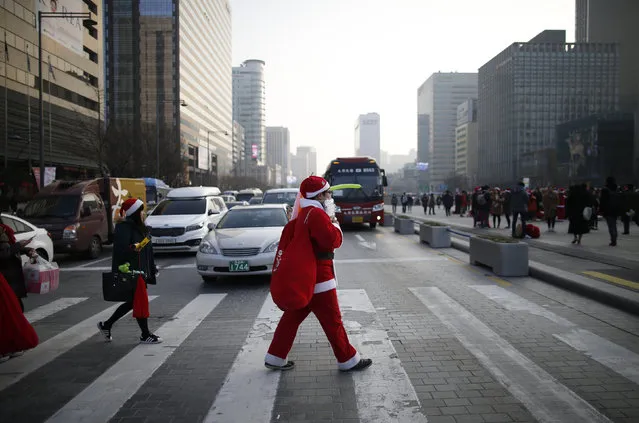 A man dressed as Santa Claus walks on zebra crossing during a Christmas charity event in central Seoul, South Korea, December 24, 2015. (Photo by Kim Hong-Ji/Reuters)