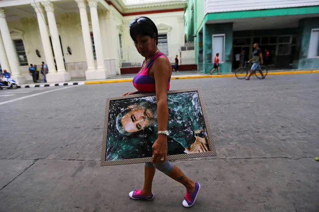 A woman carries a portrait of Cuba's late President Fidel Castro in Santa Clara, Cuba, November 30, 2016. (Photo by Ivan Alvarado/Reuters)
