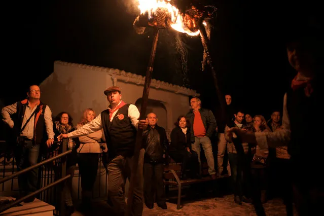 People watch as villagers hold torches during the Divina Pastora procession, as part of a festival to honour the Virgin of Los Rondeles, in the southern Spanish village of Casarabonela, near Malaga, late December 12, 2016. (Photo by Jon Nazca/Reuters)