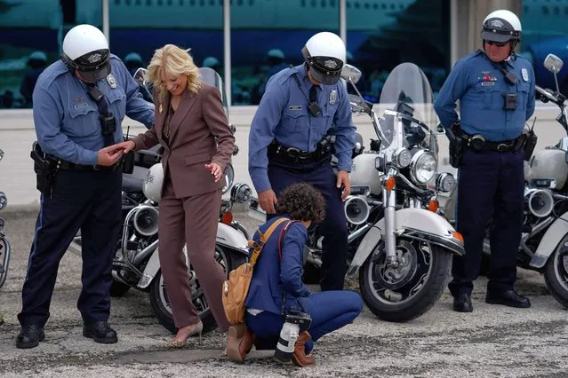 US First lady Jill Biden is helped after getting the heal of her shoe stuck in the pavement while being photographed with members of her motorcade escort before boarding her plane at Charles B. Wheeler Downtown Airport in Kansas City, Missouri on May 27, 2021, en route to Washington, DC. (Photo by Carolyn Kaster/Pool via AFP Photo)