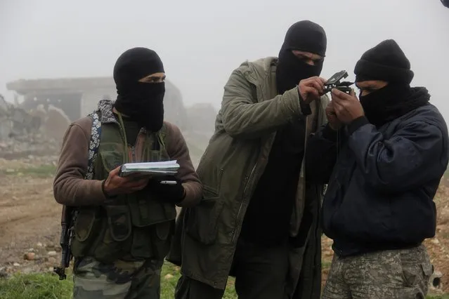 Al-Furqan brigade fighters, part of the Free Syrian Army, use a compass as they prepare to launch Grad rockets towards forces loyal to Syria's president Bashar Al-Assad located in Mork town, Hama countryside, from Khan Sheikoun, Idlib countryside January 17, 2015. (Photo by Mohamad Bayoush/Reuters)
