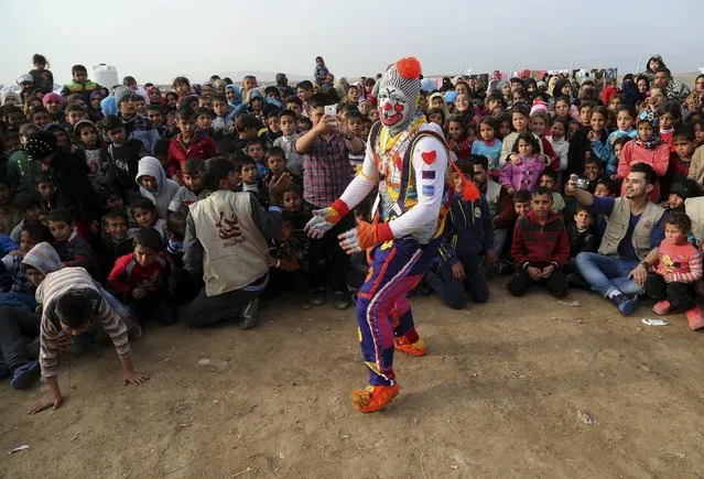 A clown performs during a New Year's celebration for internally displaced children at the Hassan Sham camp, east of Mosul, Iraq, Saturday, December 31, 2016. (Photo by Khalid Mohammed/AP Photo)