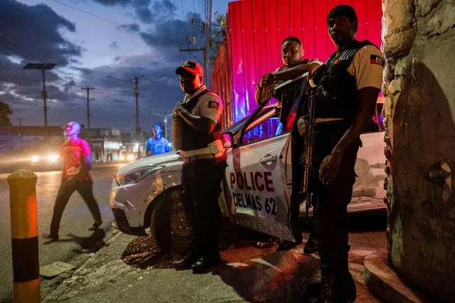 Haitian policemen stand guard at an intersection in Port-au-Prince, Haiti on July 18, 2021. (Photo by Ricardo Arduengo/Reuters)