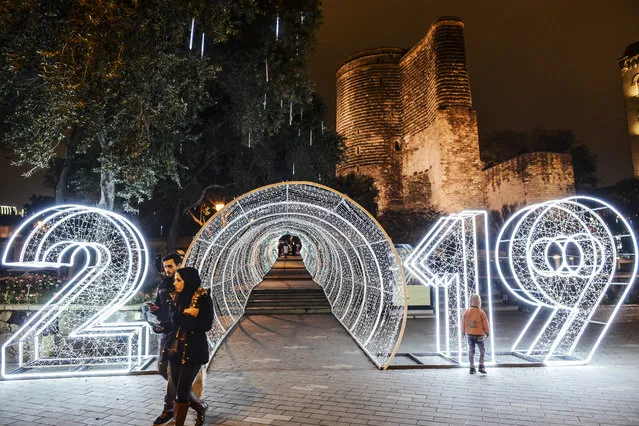 People walk past a “2019” new year decorations in front of the Maiden Tower in the Old city in central Baku, Azerbaijan on December 22, 2018. (Photo by Tofik Babayev/AFP Photo)