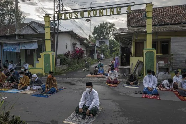 Indonesian Muslims attend  as they perform Eid Al-Adha prayer as Indonesia imposed emergency restrictions on July 20, 2021 in Yogyakarta, Indonesia. Muslims worldwide celebrate Eid Al-Adha, to commemorate the Prophet Ibrahim's readiness to sacrifice his son as a sign of his obedience to God, during which they sacrifice permissible animals, generally goats, sheep, and cows. (Photo by Ulet Ifansasti/Getty Images)
