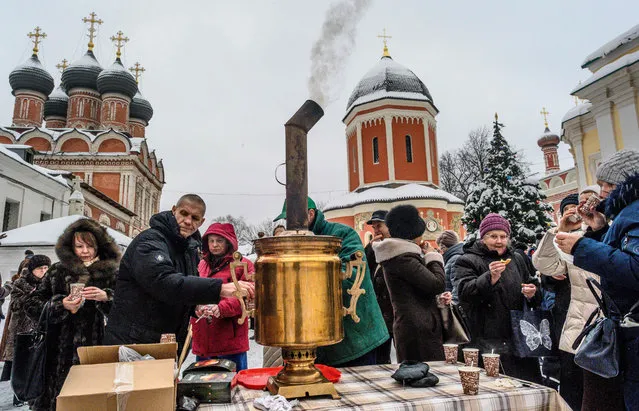 Russian Orthodox worshippers drink hot tea after a religious procession celebrating Saint Peter of Kiev, Metropolitan of Kiev and Moscow, around the Vissoko Petrovsky Monastery in Moscow on January 3, 2019. The Russian Orthodox church celebrates Christmas according to the Julian calendar on January 7. (Photo by Mladen Antonov/AFP Photo)