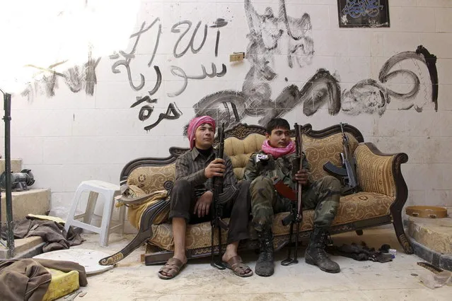 Young “Free Syrian Army” fighters pose for a picture on a couch in Old Aleppo, November 3, 2013. The Arabic words written on the wall read: “God, Syria, Free”. (Photo by Molhem Barakat/Reuters)