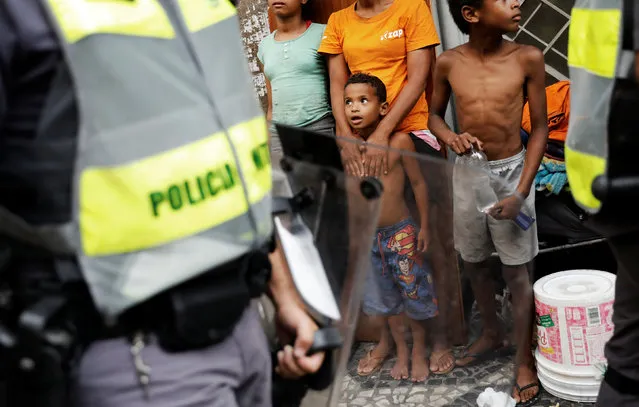 A boy looks at riot police during a protest against fare hikes for city buses in Sao Paulo, Brazil, January 22, 2019. (Photo by Nacho Doce/Reuters)