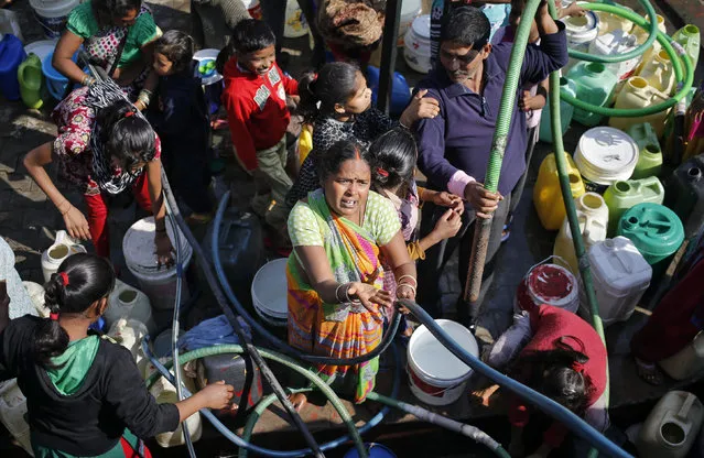 Residents fill their empty containers with water from a municipal tanker in New Delhi, India, February 22, 2016. (Photo by Anindito Mukherjee/Reuters)