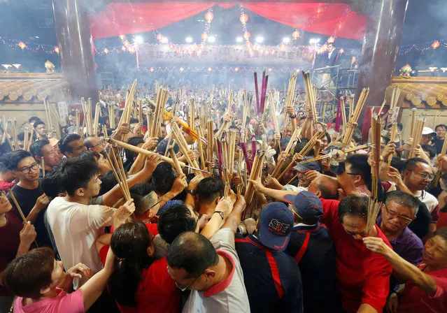 People wait to plant the first joss stick of the Lunar New Year of the Pig at the stroke of midnight at the Kwan Im Thong Hood Cho temple in Singapore, February 4, 2019. (Photo by Feline Lim/Reuters)