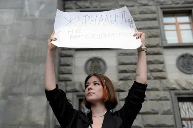 A journalist holds a poster that reads: “Journalism is not a crime” during a one-person picket in Moscow, Russia, Saturday, Aug. 21, 2021. (Photo by Denis Kaminev/AP Photo)