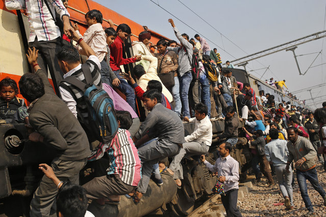 Passengers board an overcrowded train near a railway station at Loni town in the northern state of Uttar Pradesh, India, February 24, 2016. (Photo by Anindito Mukherjee/Reuters)