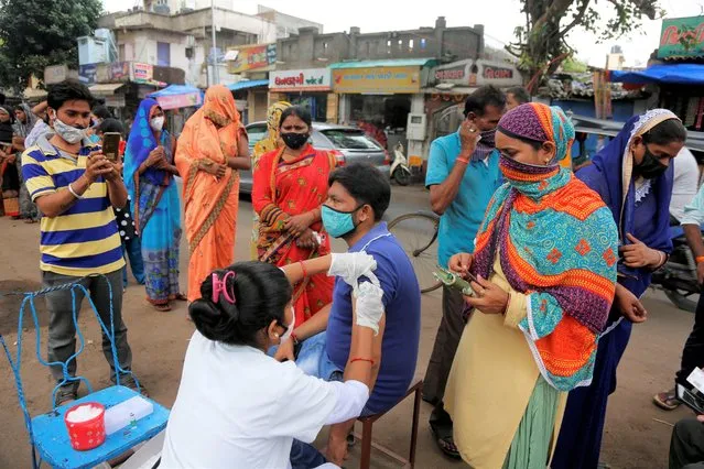 A health worker administers the vaccine for COVID-19 during a vaccination drive in Ahmedabad, India, Tuesday, August 31, 2021. (Photo by Ajit Solanki/AP Photo)