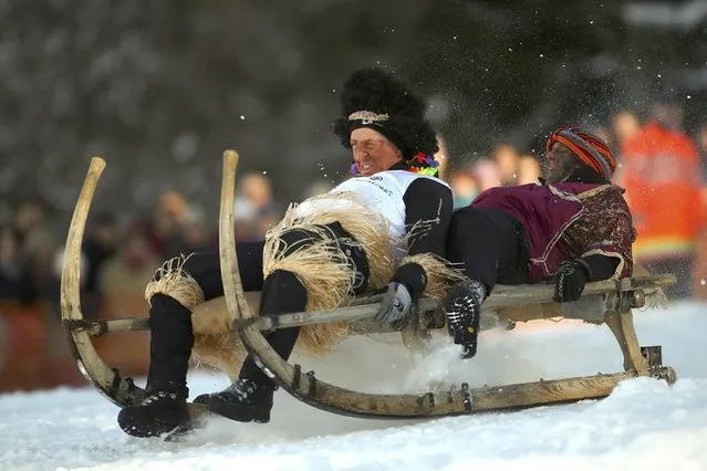 Men soar through the air on a wooden sledge during a traditional Bavarian horn sledge race, known as “Schnablerrennen”, in Gaissach near Bad Toelz, Germany, January 22, 2017. (Photo by Michael Dalder/Reuters)