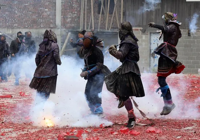 Villagers dressed as “Maogao” jump next to firecrackers during a celebration on the first day of the Chinese Lunar New Year of the Pig, in Rongshui Miao Autonomous County, Guangxi Zhuang Autonomous Region, China February 5, 2019. (Photo by Reuters/China Stringer Network)