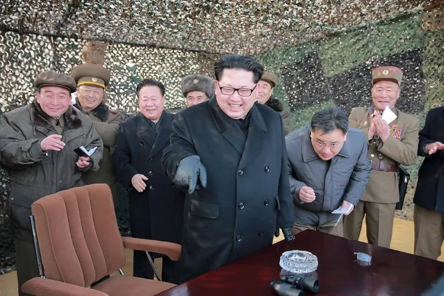 North Korean leader Kim Jong Un (C) smiles as he guides a test fire of a new multiple launch rocket system in this undated photo released by North Korea's Korean Central News Agency (KCNA) in Pyongyang March 4, 2016. (Photo by Reuters/KCNA)