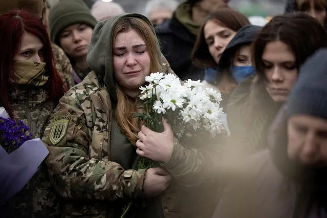 People attend the funeral ceremony of Ukrainian poet and serviceman Maksym Kryvtsov who was killed in action fighting against Russia’s attack on Ukraine, in Independence Square in Kyiv on January 11, 2024. (Photo by Thomas Peter/Reuters)