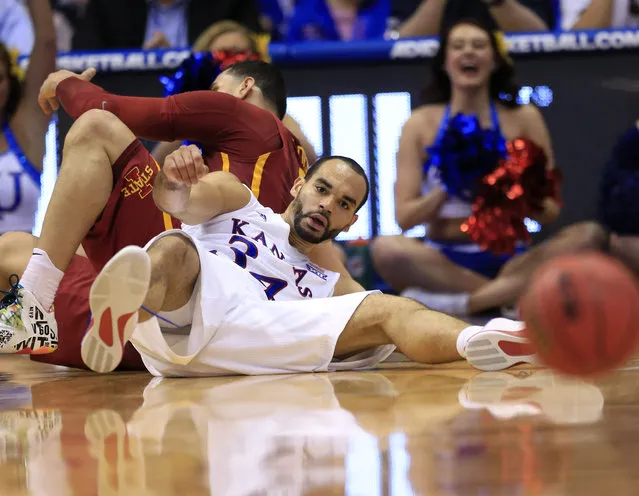 Kansas forward Perry Ellis (34) and Iowa State forward Abdel Nader, back, hit the floor during the first half of an NCAA college basketball game in Lawrence, Kan., Saturday, March 5, 2016. Ellis passed to a teammate from the floor. (Photo by Orlin Wagner/AP Photo)