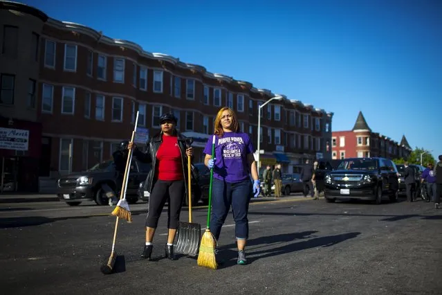 People clean up Pennsylvania avenue as Maryland State police stand guard in Baltimore, Maryland April 28, 2015. (Photo by Eric Thayer/Reuters)