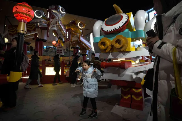 A child reacts near a lion dancer made of Lego blocks as Lego showcasing the Lunar New Year theme at an outdoor shopping mall in Beijing, Thursday, February 15, 2024. Chinese people are enjoying a weeklong holiday for the Lunar New Year and visiting various temple fairs and carnivals held in the cities around China. (Photo by Andy Wong/AP Photo)