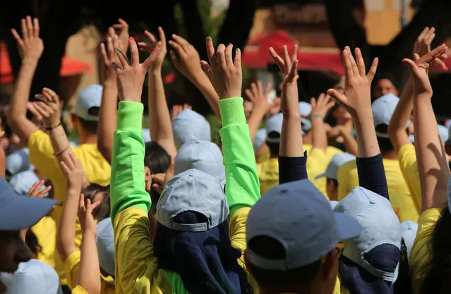 Lebanese students wave their hands as they dance during the event The Big Dance “Beats for Peace”, at the Parliament square, in downtown Beirut, Lebanon, Saturday, May 9, 2015. (Photo by Hussein Malla/AP Photo)