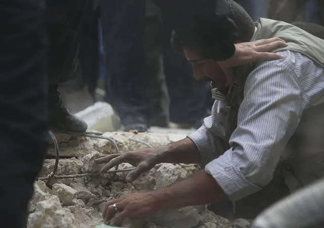 A father reacts while trying to search for his daughters under the rubble at a site hit by what activists say was an air strike by forces loyal to Syrian President Bashar al-Assad in the Duma neighborhood of Damascus November 4, 2013. (Photo by Bassam Khabieh/Reuters)