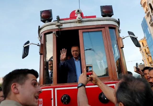 Turkish President Tayyip Erdogan greets his supporters as he rides on a vintage tram at Taksim Square in central Istanbul, Turkey, May 12, 2019. (Photo by Murad Sezer/Reuters)