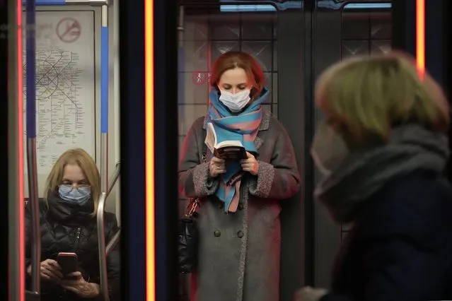 People wearing face masks travel on a metro train in Moscow, Russia, Thursday, November 18, 2021. Coronavirus deaths in Russia hit record highs for the second straight day Thursday, while new daily cases appeared to be taking a downward trend but still remained higher than during previous waves of the pandemic. (Photo by AP Photo/Stringer)