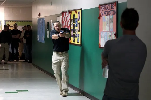 Joe Deedon, president of TAC ONE Consulting, demonstrates searching for a shooter in a middle school during an Active Shooter Response course offered by TAC ONE in Denver April 2, 2016. (Photo by Rick Wilking/Reuters)