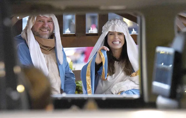Jeffery and Katie Tatum play Joseph and Mary as they wave to people driving through at Dalton, Ga., on Wednesday, December 8, 2021. The church hosted the drive thru nativity event for three nights. (Photo by Matt Hamilton /Chattanooga Times Free Press via AP Photo)