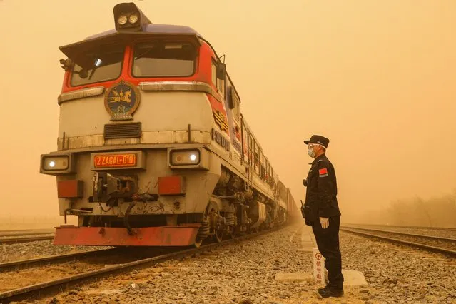 This photo taken on March 27, 2024 shows a police officer standing guard at a border checkpoint during a sandstorm in Erenhot, in northern China's Inner Mongolia autonomous region. (Photo by AFP Photo/China Stringer Network)