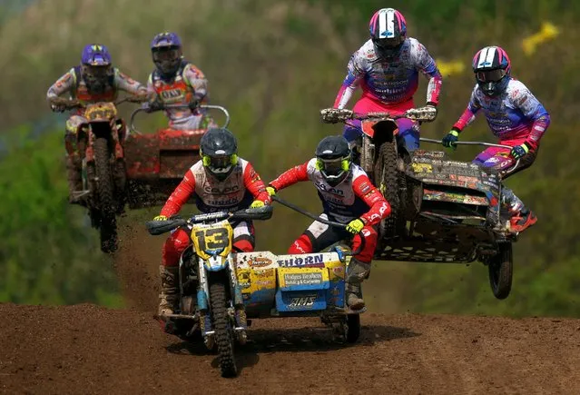 Riders compete during the NETT sidecarcross championship in Middlesbrough, Britain on April 14, 2024. The daredevil sport is a branch of motocross racing in which bikes are designed to take the weight of two people. (Photo by Lee Smith/Reuters)