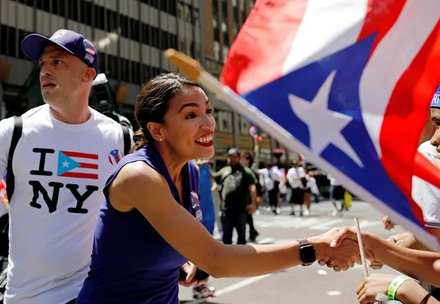 Representative Alexandria Ocasio-Cortez shakes hands on 5th Avenue at the annual Puerto Rican Day Parade in Manhattan, New York, U.S. June 9, 2019. (Photo by Jose Alvarado Jr./Reuters)