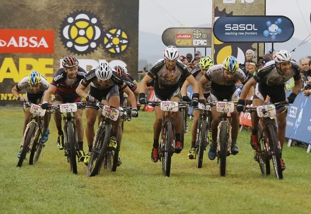 Former Cape Epic winner, Switzerland's Christoph Sauser (C), sprints with other riders for second place during Stage 1 of the annual ABSA Cape Epic mountain bike stage race, Cape Town, South Africa, 24 March 2014. (Photo by Kim Ludbrook/EPA)