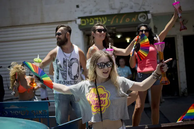 People dance during the annual Gay Pride Parade in Tel Aviv, Israel, Friday, June 12, 2015. Thousands of bare-chested muscular men, drag queens in heavy makeup and high heels, women in colorful balloon costumes and others partied at Tel Aviv's annual gay pride parade on Friday, the largest event of its kind in the region. (AP Photo/Ariel Schalit)