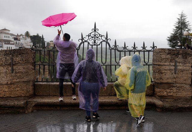 A tourist's umbrella blows upside down as he and his family use raincoats to cover themselves from the heavy rain and high winds as Storm Nelson hits Spain during the Holy Week in Ronda, Spain on March 28, 2024. (Photo by Jon Nazca/Reuters)