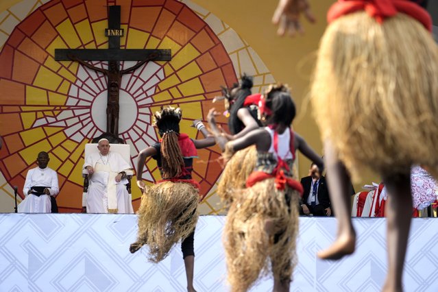 Pope Francis, second from left, looks at traditional dancers performing at the Martyrs' Stadium In Kinshasa, Democratic Republic of Congo, Thursday, February 2, 2023. Francis is in Congo and South Sudan for a six-day trip, hoping to bring comfort and encouragement to two countries that have been riven by poverty, conflicts and what he calls a “colonialist mentality” that has exploited Africa for centuries. (Photo by Gregorio Borgia/AP Photo)