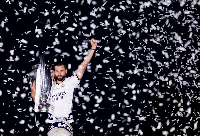Team captain Nacho Fernandez of Real Madrid raises the trophy over the top of the Cibeles statue during Real Madrid UEFA Champions League Trophy Parade celebrating their victory of 15th Champions League at Cibeles Square in Madrid, Spain on June 02, 2024. (Photo by Ana Beltran/Reuters)