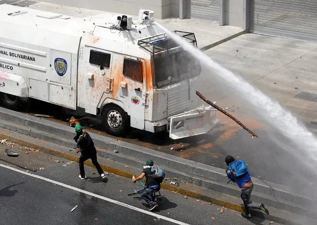 A police water cannon disperses demonstrators during an opposition rally in Caracas, Venezuela April 6, 2017. (Photo by Christian Veron/Reuters)